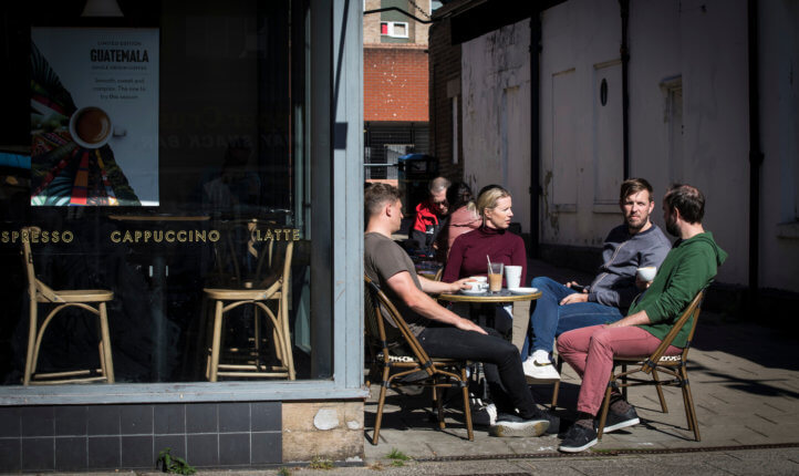 A group of four sitting talking outside a café
